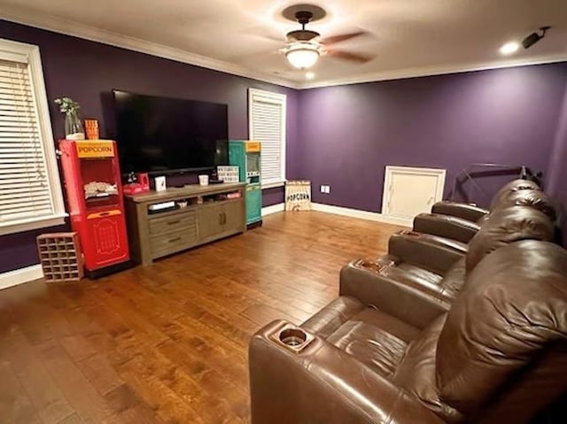 cinema room featuring crown molding, ceiling fan, and hardwood / wood-style floors