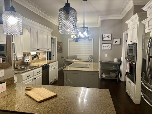 kitchen with pendant lighting, a kitchen island, white cabinets, and appliances with stainless steel finishes