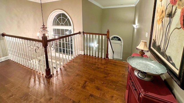 staircase featuring a notable chandelier, hardwood / wood-style flooring, and ornamental molding