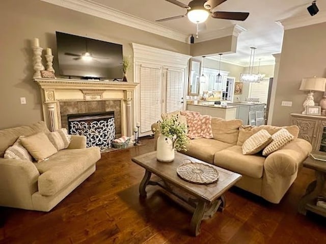 living room featuring dark wood-type flooring, ceiling fan, and crown molding