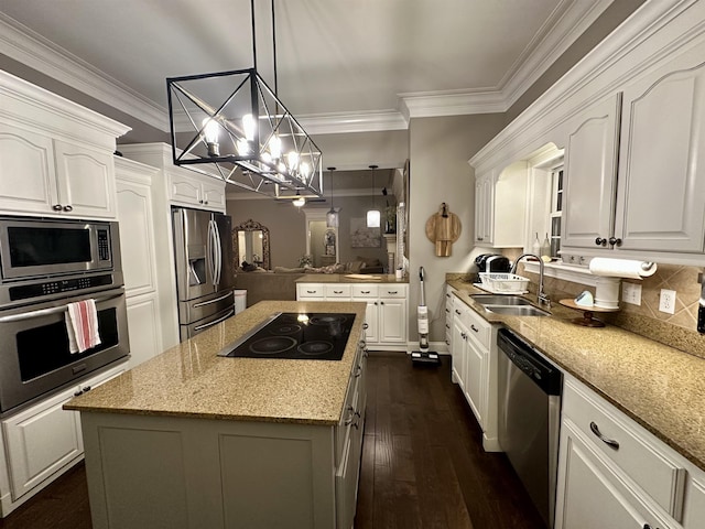 kitchen featuring sink, appliances with stainless steel finishes, light stone counters, white cabinets, and a kitchen island