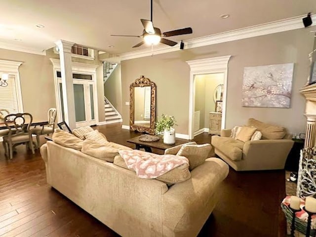 living room with dark hardwood / wood-style flooring, ceiling fan with notable chandelier, and ornamental molding