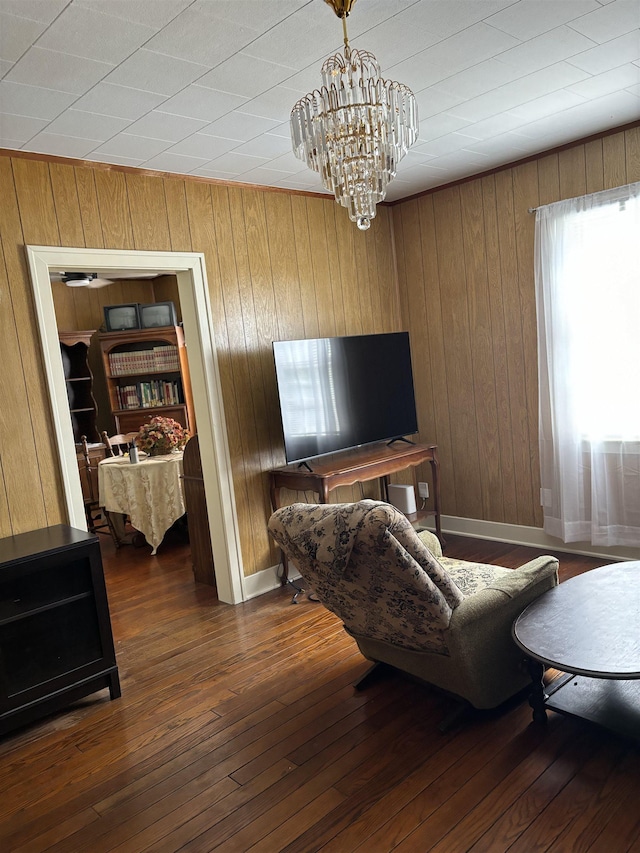 living room with wood walls, dark hardwood / wood-style floors, and a notable chandelier