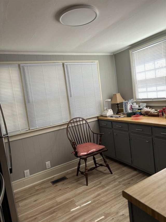 sitting room with light wood-type flooring and ornamental molding