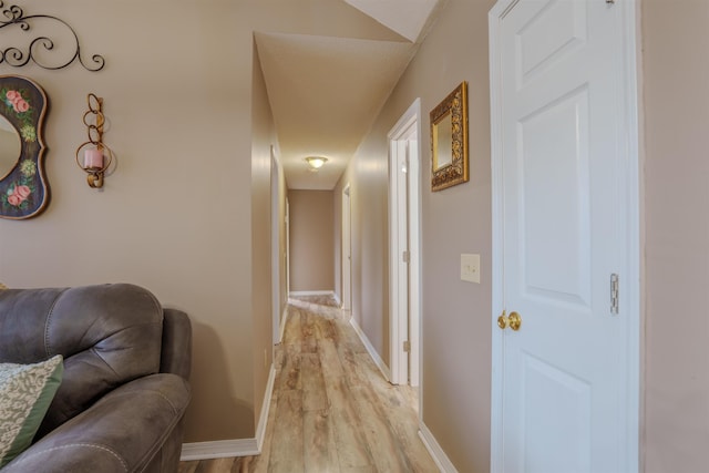 hallway with light wood-style floors and baseboards