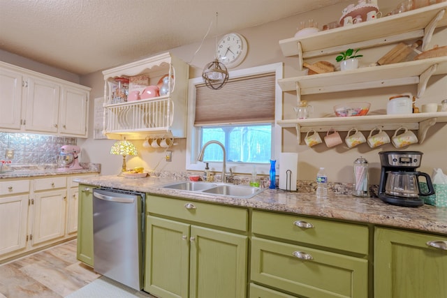 kitchen featuring green cabinets, a sink, stainless steel dishwasher, and open shelves