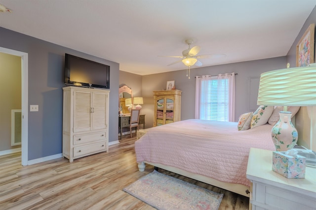 bedroom with visible vents, light wood-type flooring, a ceiling fan, and baseboards