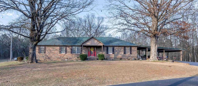 ranch-style home with an attached carport, crawl space, metal roof, and a front yard