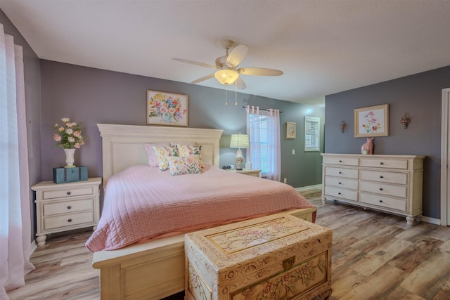 bedroom with baseboards, ceiling fan, and light wood finished floors