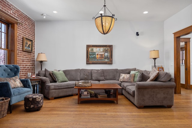 living room with recessed lighting, brick wall, and light wood finished floors