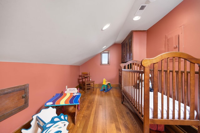 bedroom featuring visible vents, baseboards, lofted ceiling, wood-type flooring, and recessed lighting