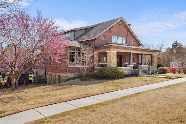 view of front of property featuring covered porch and a front yard