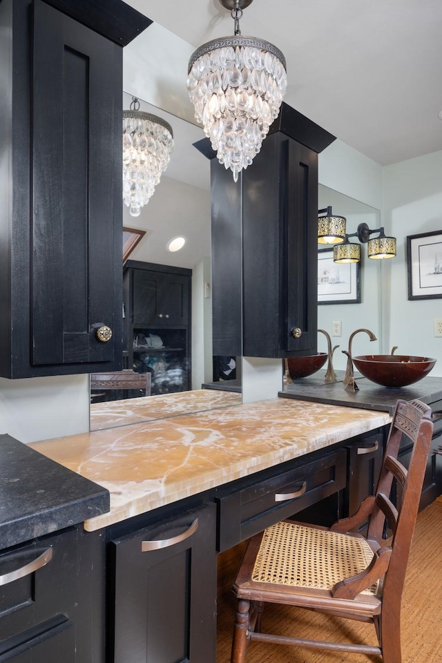 interior space featuring pendant lighting, a notable chandelier, a sink, and wood finished floors