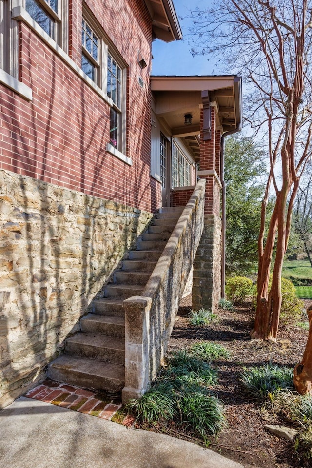 view of home's exterior featuring stairs and brick siding