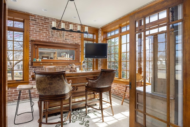 bar featuring carpet, indoor wet bar, and brick wall