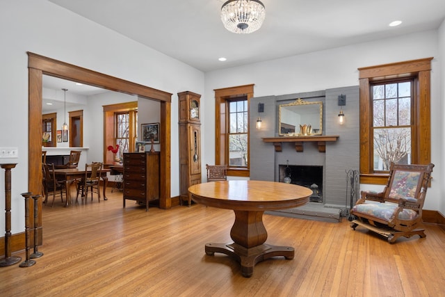 entrance foyer with a notable chandelier, recessed lighting, a brick fireplace, wood finished floors, and baseboards