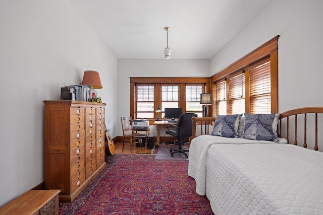 bedroom with baseboards and dark wood-style flooring