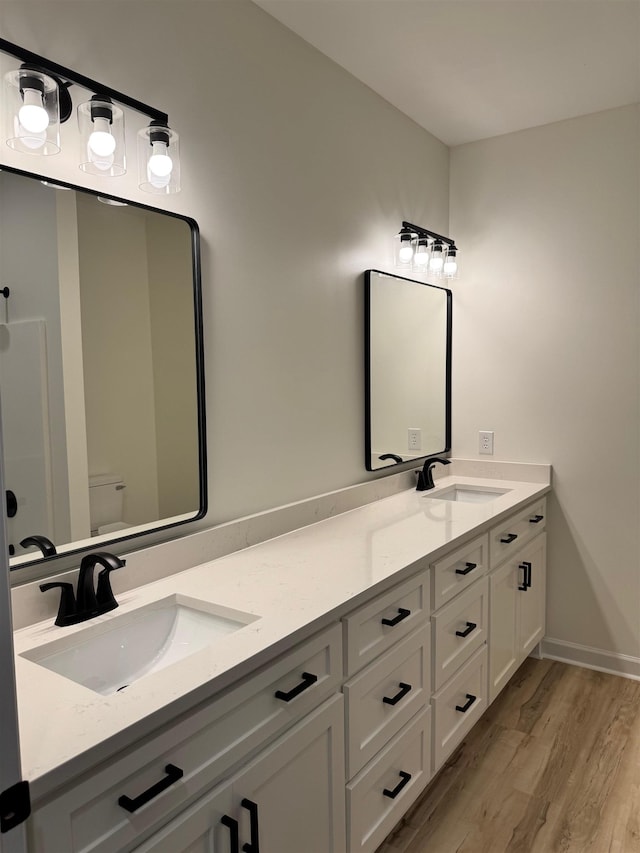  - full bathroom with wood finished floors and double vanity