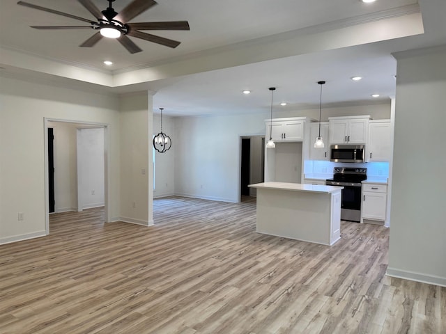  - kitchen with appliances with stainless steel finishes, ornamental molding, a ceiling fan, open floor plan, and light wood finished floors