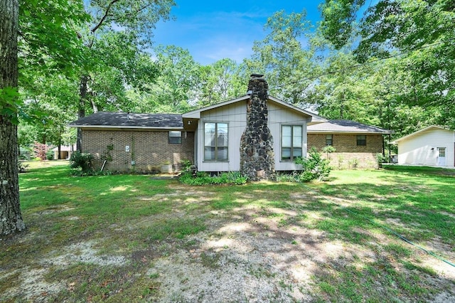 rear view of property with a lawn