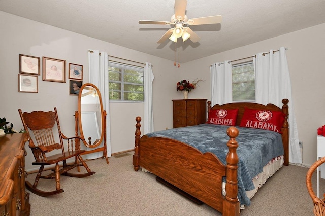 carpeted bedroom with ceiling fan and a textured ceiling