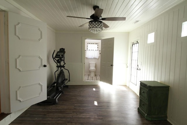 exercise room with ceiling fan, wooden ceiling, crown molding, and dark wood-type flooring