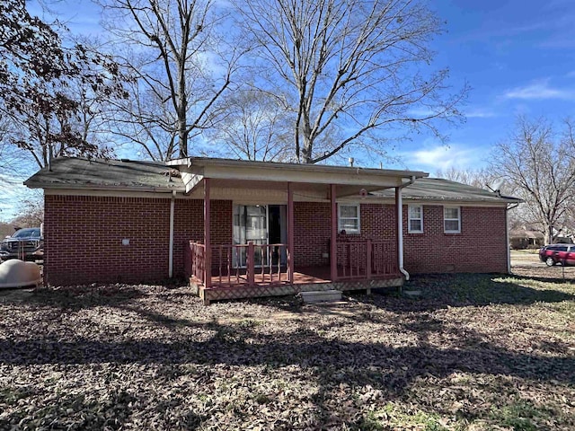 rear view of house featuring a porch