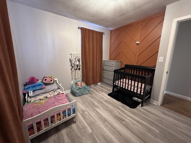 bedroom featuring light hardwood / wood-style floors and a textured ceiling