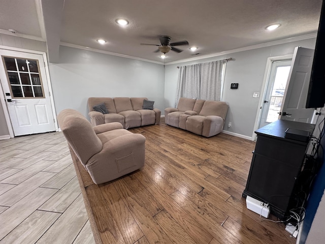 living room featuring ornamental molding, ceiling fan, and light hardwood / wood-style flooring