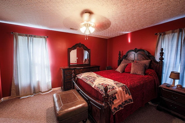 carpeted bedroom with ceiling fan and a textured ceiling