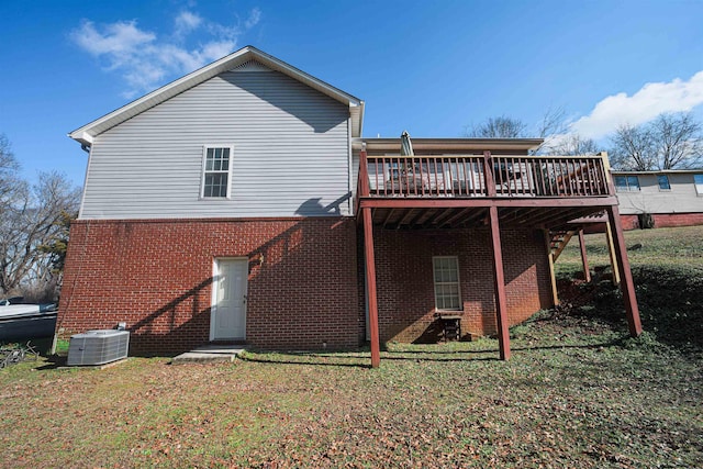 rear view of house with a deck, a yard, and central AC