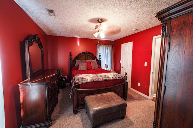 carpeted bedroom featuring ceiling fan and a textured ceiling