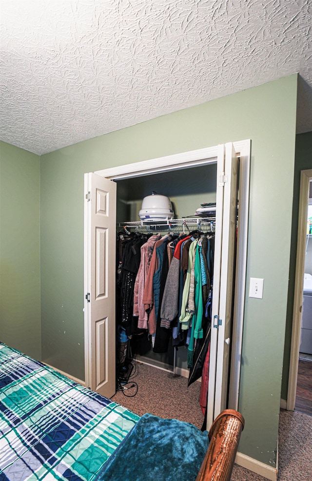 carpeted bedroom with a textured ceiling and a closet