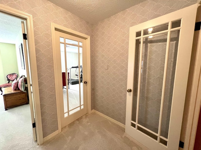 bathroom with a stall shower, a textured ceiling, and wallpapered walls