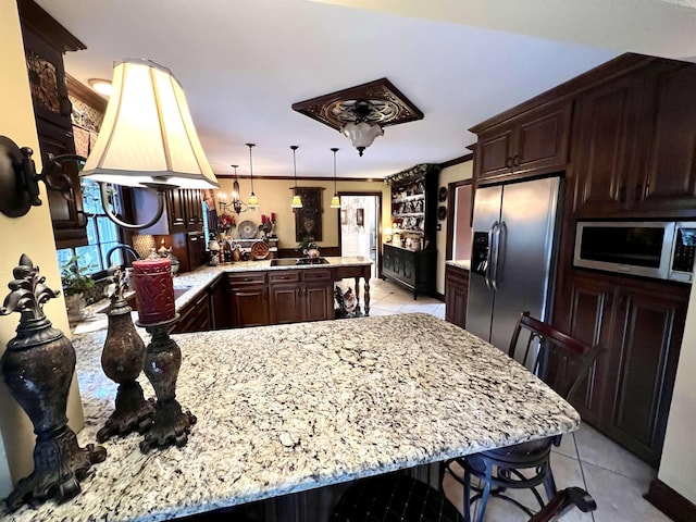 kitchen featuring light tile patterned floors, a peninsula, light stone countertops, stainless steel appliances, and dark brown cabinets