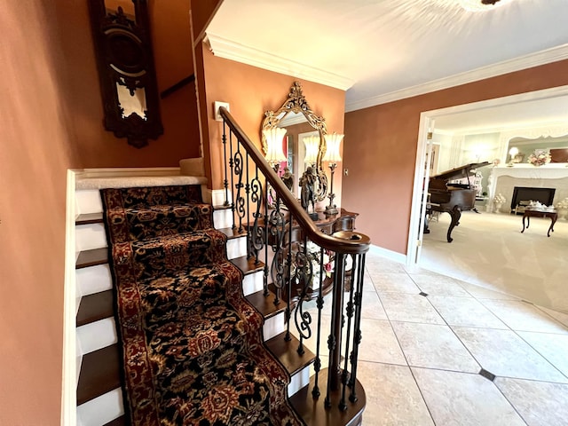 stairway featuring tile patterned flooring, carpet floors, a fireplace, baseboards, and crown molding