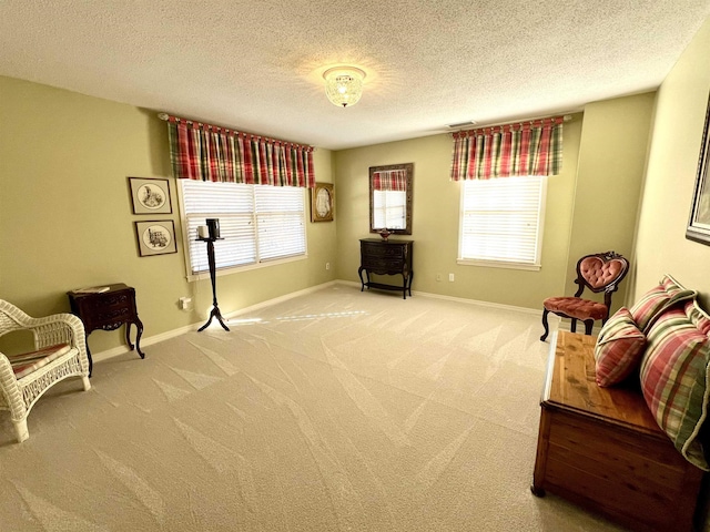 living area featuring baseboards, visible vents, a wealth of natural light, and light colored carpet