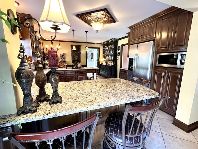 kitchen featuring light tile patterned floors, a peninsula, dark brown cabinets, appliances with stainless steel finishes, and crown molding