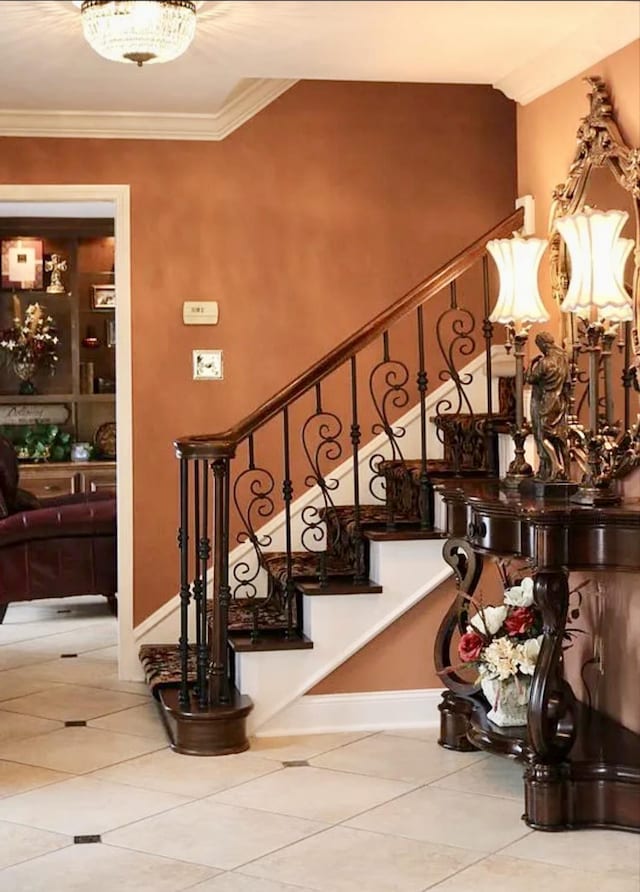 stairs featuring baseboards, crown molding, and tile patterned floors