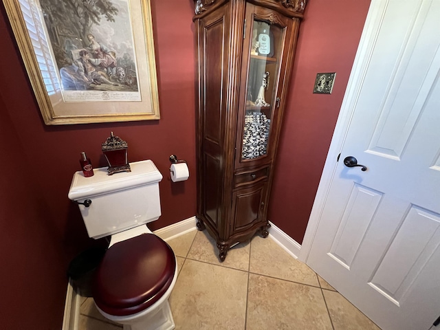 bathroom with tile patterned flooring, toilet, and baseboards