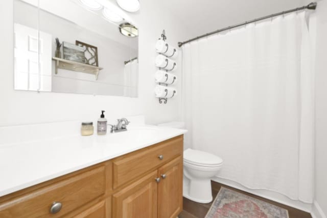 bathroom with curtained shower, vanity, and toilet