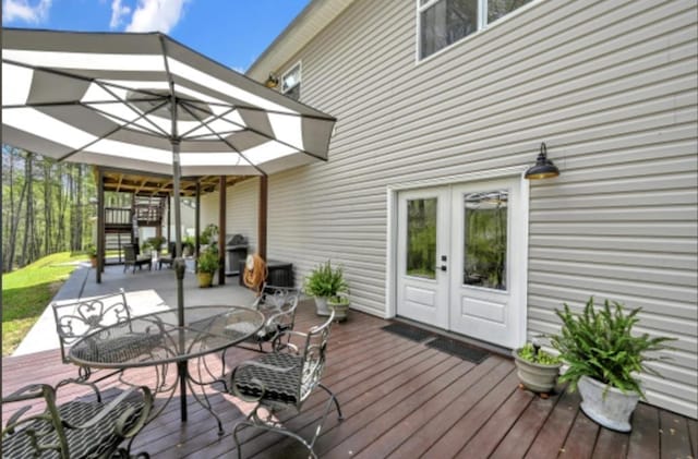 wooden terrace featuring area for grilling and french doors