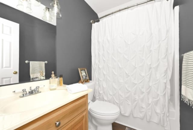 full bathroom featuring vanity, shower / bath combo, and toilet