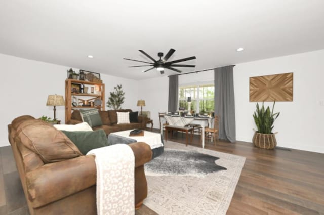 living room with ceiling fan and dark wood-type flooring