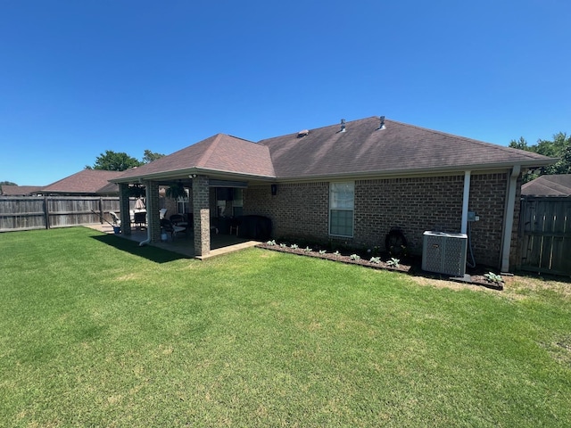  - rear view of house featuring central air condition unit, a patio area, brick siding, and roof with shingles