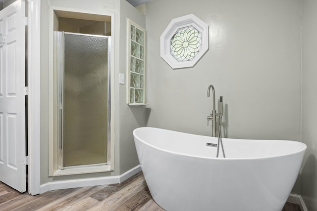 bathroom featuring hardwood / wood-style floors and plus walk in shower