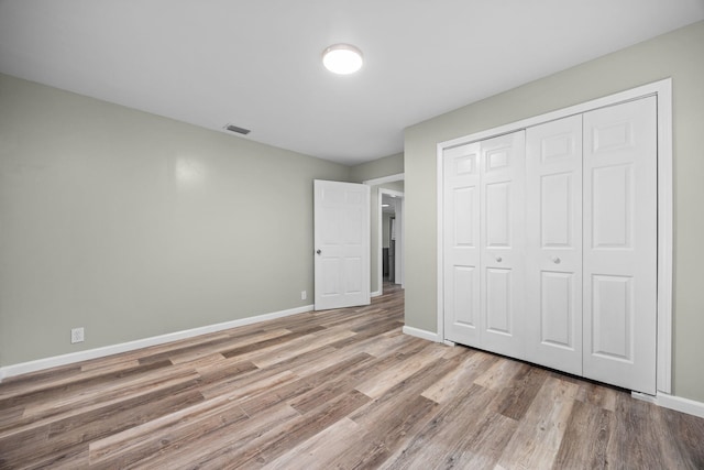 unfurnished bedroom featuring a closet and light hardwood / wood-style flooring