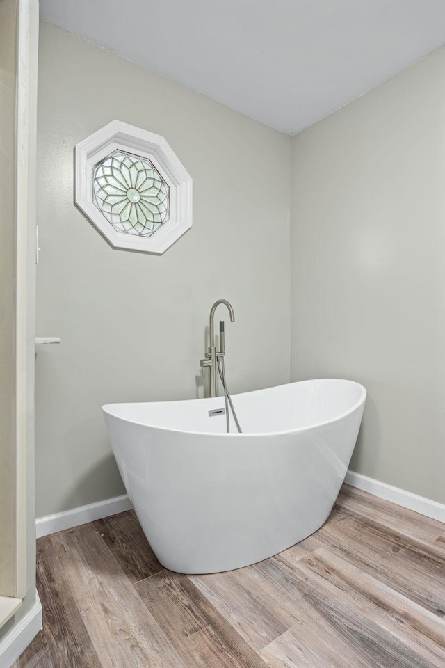 bathroom with a washtub and hardwood / wood-style floors