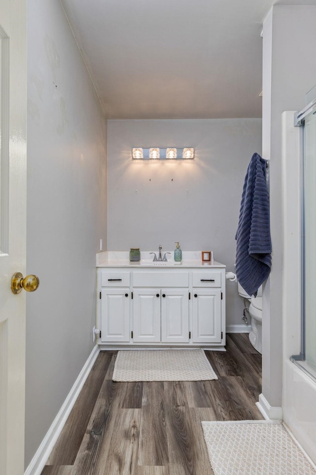  - bathroom featuring wood finished floors, vanity, toilet, and baseboards