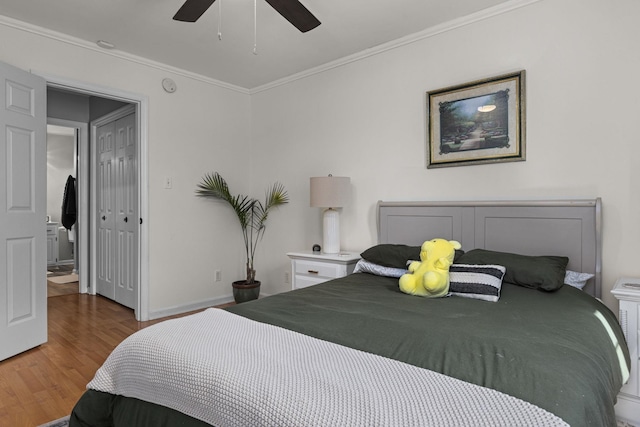  - bedroom featuring wood finished floors, ornamental molding, baseboards, and a ceiling fan